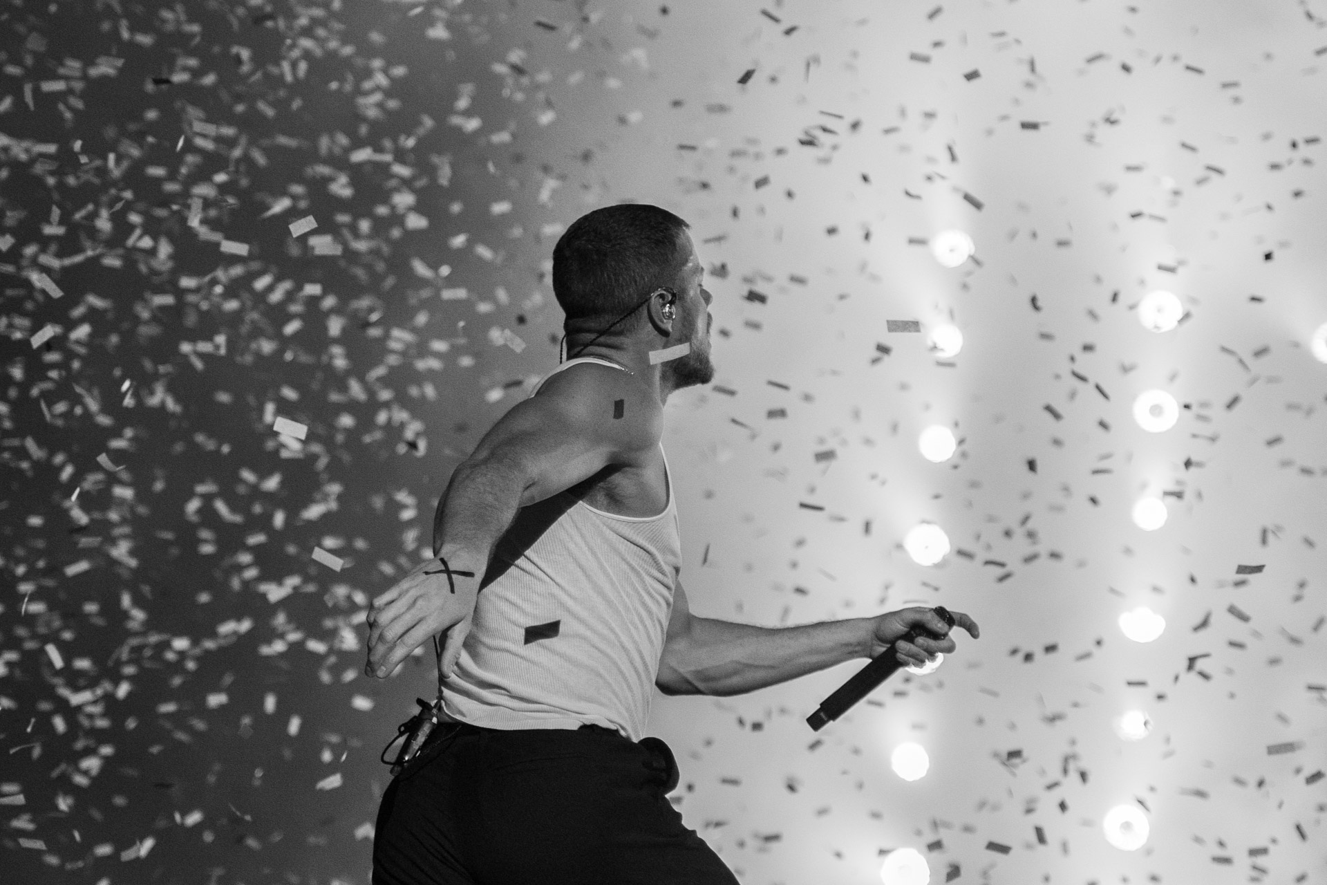 Singer with microphone on stage, black and white